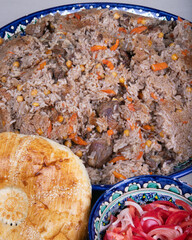 The traditional uzbek "pilaf" with flat bread and tomato 
