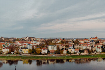 Fototapeta premium The red tile roofs of old European city Meissen on the embankment of river Elba