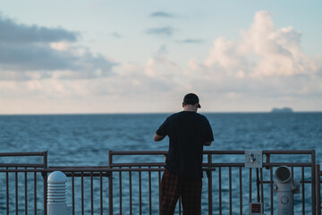 Fototapeta premium man looking at the sea fisherman sky clouds blue cap