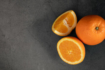 Fresh orange on dark stone background, top view, copy space