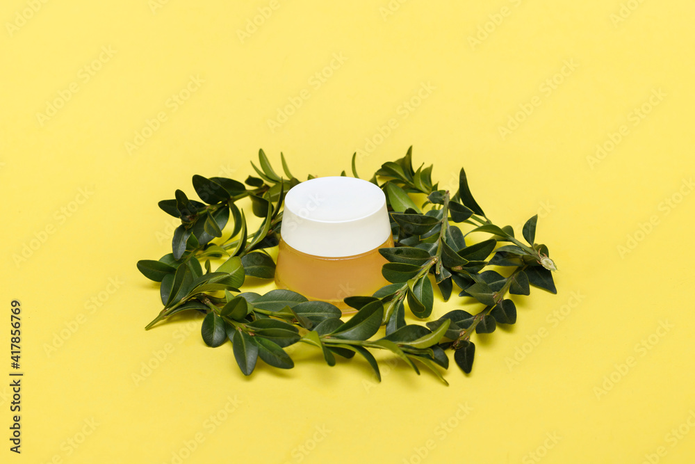 Canvas Prints jar of cream with green leaf decor on a yellow background