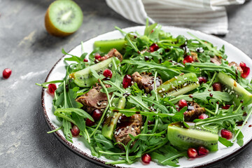 Warm salad of roast liver, kiwi and pomegranate and fresh arugula