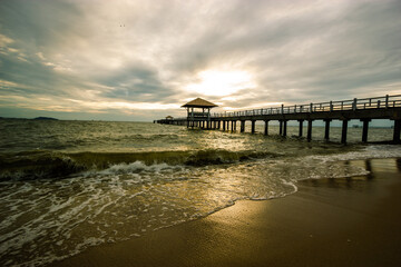 wood bridge in evening at Casaluna village in Thailand , wooden pier on the beach ,Wooded bridge in the port between sunrise.