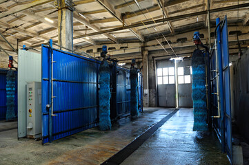 Automatic tunnel car wash brushes, control panel and gates ready for work at the trolley bus depot