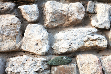 Texture of a stone wall. Part of a building wall. Large stones. Close-up.