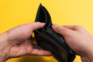 open an empty wallet at the end of the month. on a yellow background is the time to earn, selective focus