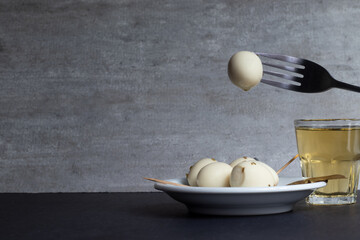 Eating pickled quail eggs with beer.