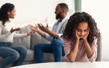 Obraz premium Sad girl with her fighting parents in the background