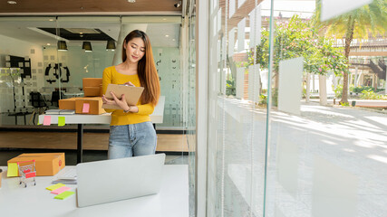 Young Asian selling things online, starting a small business in a working cardboard box Seller provides shipping boxes for customers, online sales or e-commerce sme.