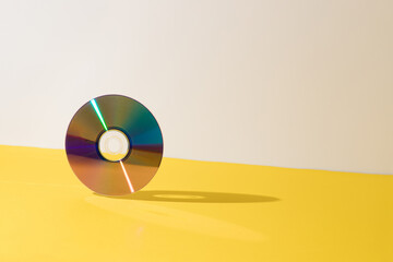 CD on a yellow and gray background set upright. Retro music style.Minimal vintage concept.