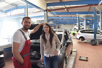 Obraz premium Customer service: car mechanic and customer discuss the repair of a vehicle on site