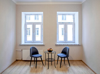 Modern interior design concept. Minimalistic style. Two blue armchairs and a table with fruit.