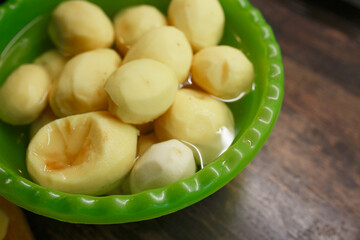 Peeled raw potatoes in a dish.