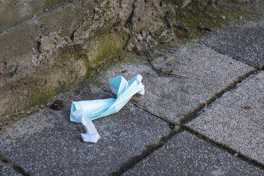 Used surgical mask thrown on the street , COVID-19 concept,