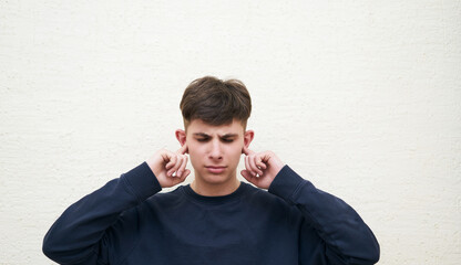plug ears emotion, man covered his ears from unpleasant noise and conversations