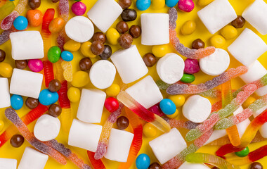 Background texture from different sweets on a yellow background. View from above