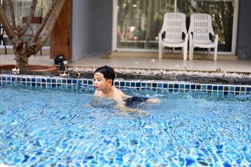 Asia children relaxation and playing in the water In the hotel pool during the holidays.