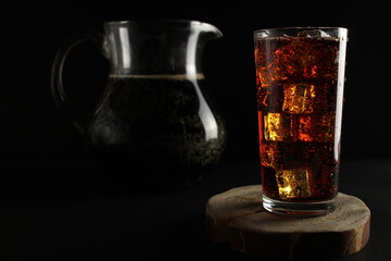 kvass drink in a dark low key kvass drink in an iced glass and a jug with a drink with room for text