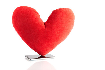 Big red toy heart at smart phone like symbol icon followers from social network isolated on white background. Social media concept.
