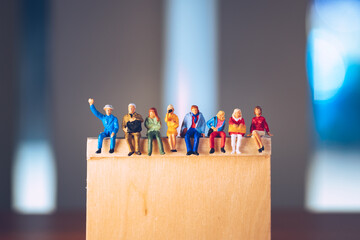 Miniature people, man and woman sitting together on blurry background using as business meeting and social concept