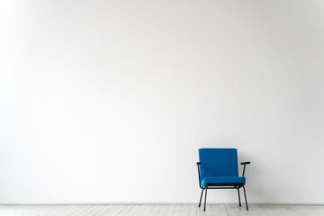 Empty room with a blue chair on a white wall background