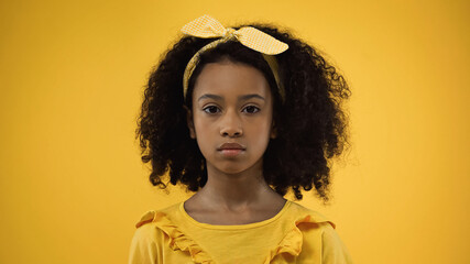 curly african american girl in headband with bow isolated on yellow
