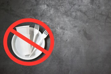 White plastic tableware on a concrete background as a symbol of environmental pollution. Ban single use plastic. Flat lay, copy space.