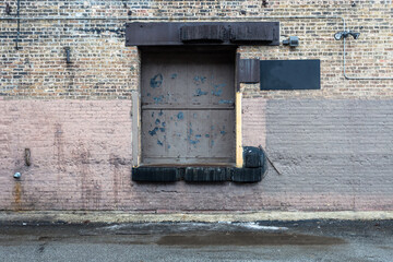 Loading dock on back of vintage brick industrial building on wet day in urban Chicago