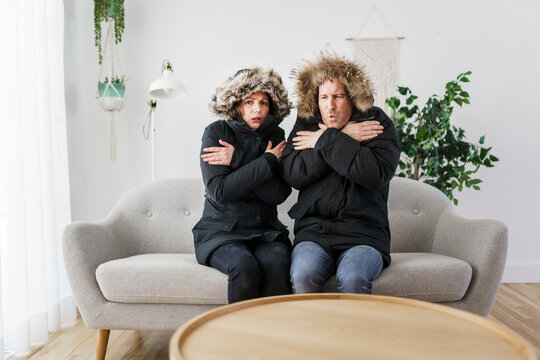 Couple have cold on the sofa at home with winter coat
