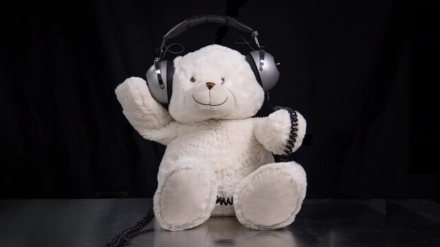 Teddy bear moving around with headphones