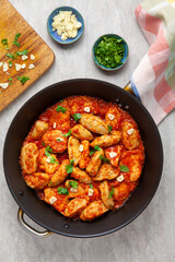 Poultry and dumplings stew in tomato sauce with garlic and coriander garnish. Romanian cuisine: Ostropel de Oltenia.