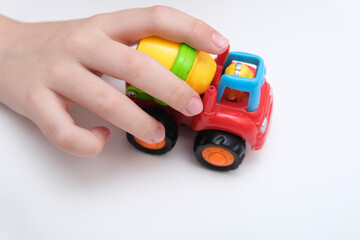 A boy playing toy cars on a white table