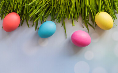 Easter background with Easter eggs and spring grass. Row of easter eggs in fresh green grass.