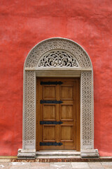 Carved Medieval Door in the Red Stucco Wall