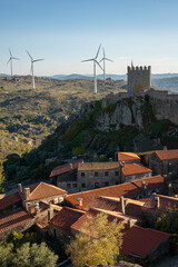 View of Sortelha castle and antique stone houses and wind turbines, in Portugal