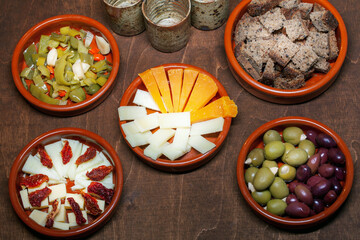 Set of tapas appetizers prepared at home in ceramic bowls.
