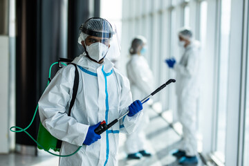 Portrait of doctor in white safety protective uniform ready desinfect covid-19 contamination...