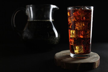 kvass drink in a dark low key kvass drink in an iced glass and a jug with a drink with room for text