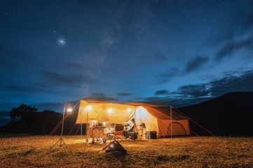 Zelfklevend Fotobehang Tourists in yellow tent camping on hill with milky way in the night sky © Mumemories