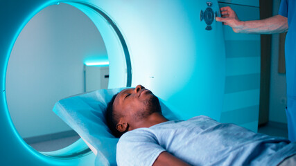African American patient entering CT machine in clinic