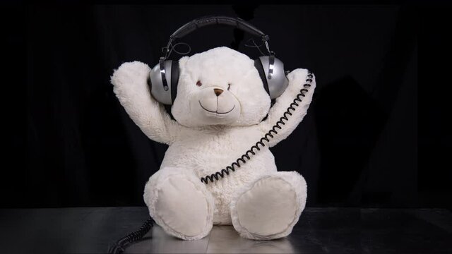 Teddy bear moving around with headphones
