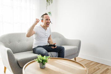 Concentrated man having fun with video games while on a sofa