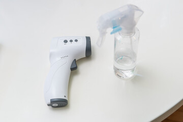 非接触型の体温計（検温器）とアルコール消毒のスプレーボトル