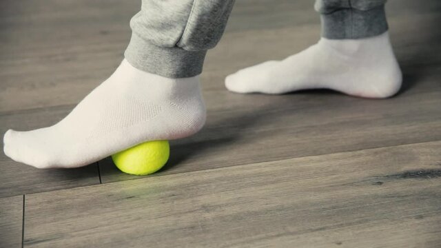 Warm up the muscles of the foot with a tennis ball.