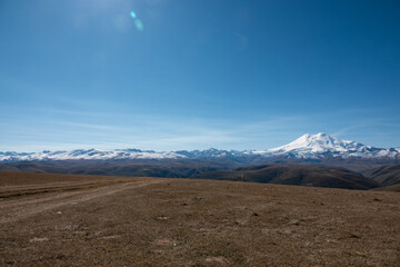 Fototapeta na wymiar Elbrus And Green Hills At Sunny Summer Day. Elbrus Region, North Caucasus, Russia
