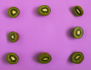  Cutted kiwi arrangement against purple background lay out