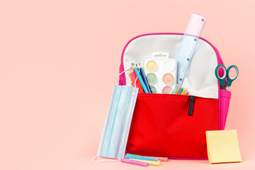 Back to school concept backpack full of school supplies and face mask