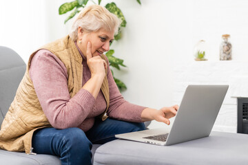 Elderly woman having a video call with her family, smiling and waving. Quarantine time