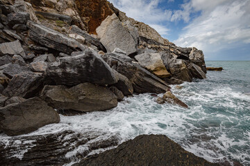 Fototapeta na wymiar Seascape. Stormy sea on a windy day: blue waves breaks on the stone shore