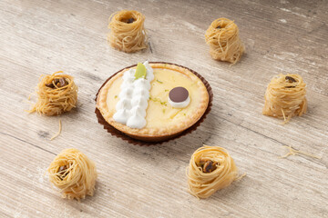 dessert decoration, there is a lemon cake with cream and chocolate, small appetizers in the form of nests, wooden texture background in studio